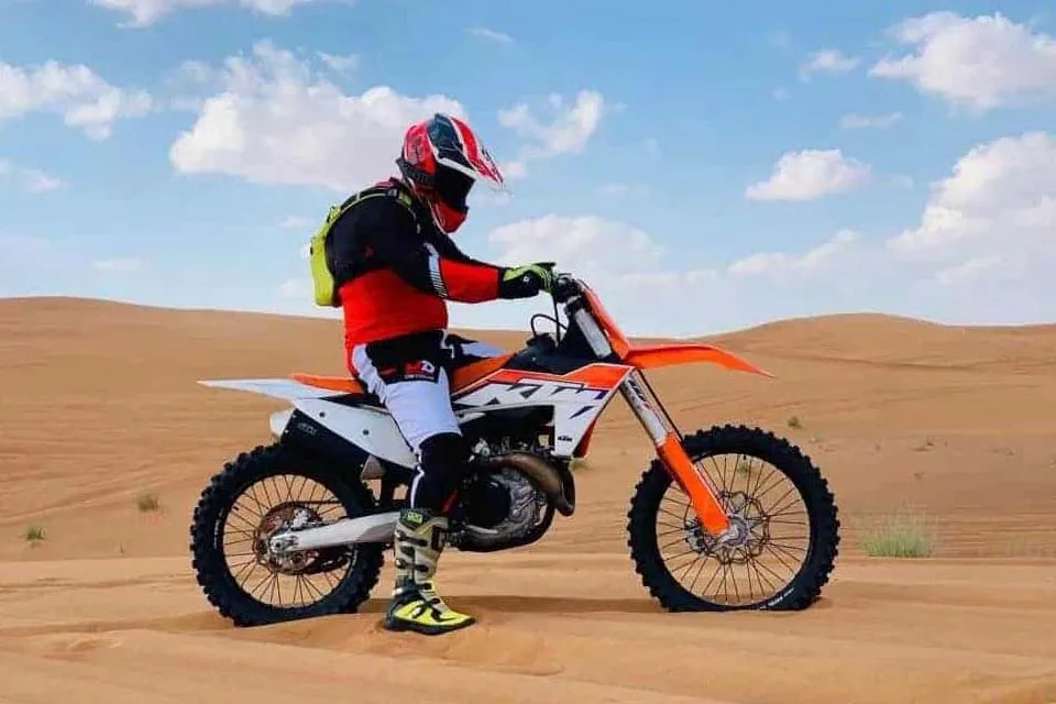 KTM dirt bike rental in Dubai desert safari tour, high speed action shot